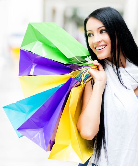 Beautiful shopping girl holding bags at the mall