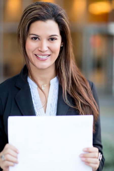 Successful businesswoman holding white documents and smiling