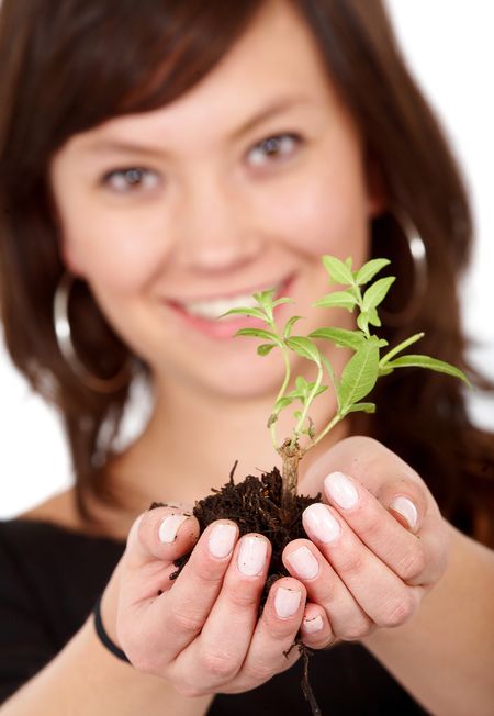 woman holding a newly born tree - over a white background