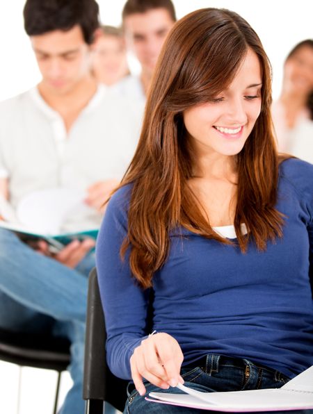 Female student in class reading from her notebook