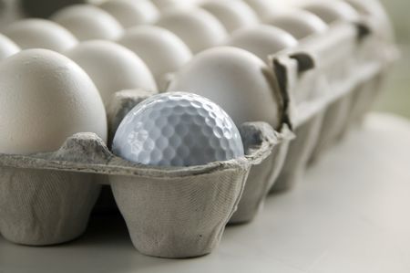 Golf ball and eggs in an egg carton
