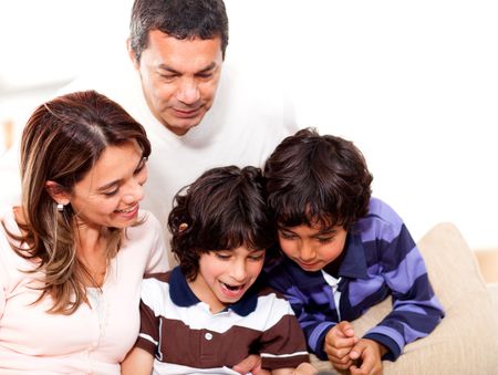 Happy family at home reading a book together