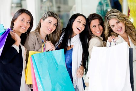 Group of happy shopping women holding bags and smiling