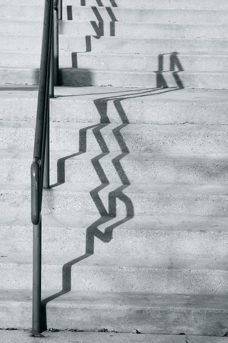 Shadows of handrail on concrete stairs