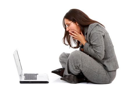 Business woman in panic on a laptop computer - isolated over a white background
