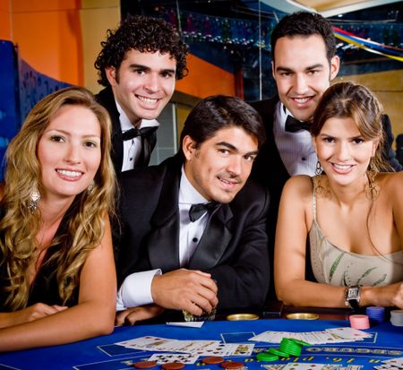 Group of people smiling playing roulette at the casino