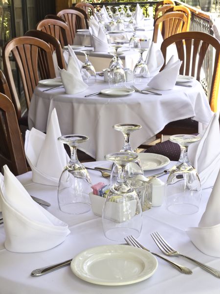 Table settings on white linen at outdoor restaurant