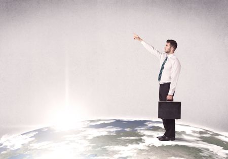 A young elegant office worker standing on top of a drawn world globe while celebrating his successful career concept.