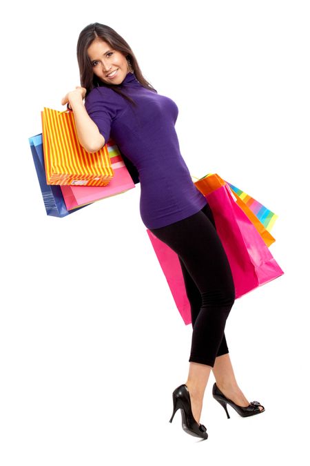 girl standing and smiling carrying shopping bags isolated over a white background