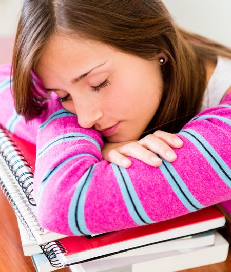 Tired female student falling asleep while studying