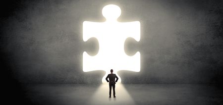 Businessman  standing and looking to a big puzzle piece