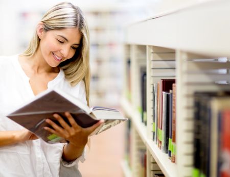 Beautiful woman reading a book at the library