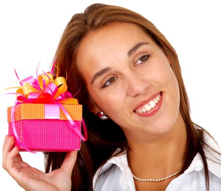 girl holding a gift and smiling - isolated over a white background