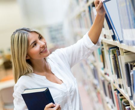 Female student looking for a book at the library