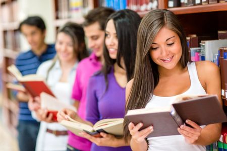 Group of young people reading books at the library