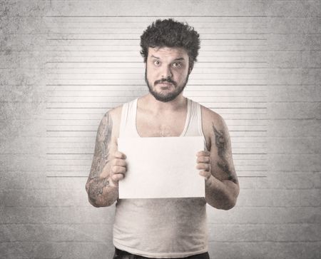 Gangster in front of a wall with table on his hand.