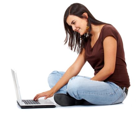 casual girl sitting on the floor working on a laptop computer isolated over a white background