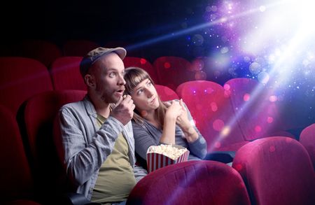 Romantic couple cuddling and watching the miraculous part of the film