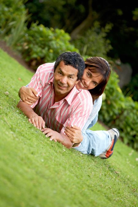 happy couple lying on the grass outdoors