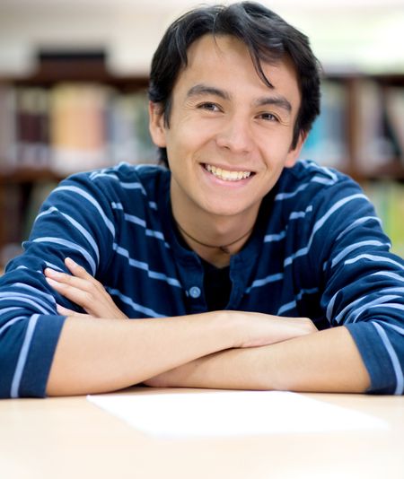 Happy male student smiling at the library
