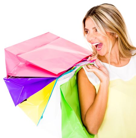 Happy female shopper holding bags - isolated over a white background
