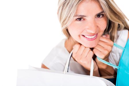 Beautiful female shopper holding shopping bags - isolated over white background