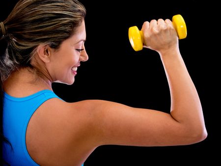 Athletic woman lifting free weights - isolated over a black background