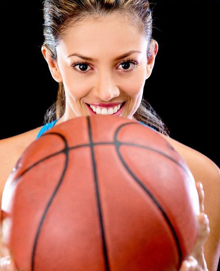 Female basket player holding a ball and smiling