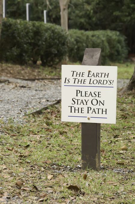 Sign by garden path on university campus