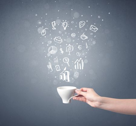 Young female hand holding coffee cup with business related drawings above it