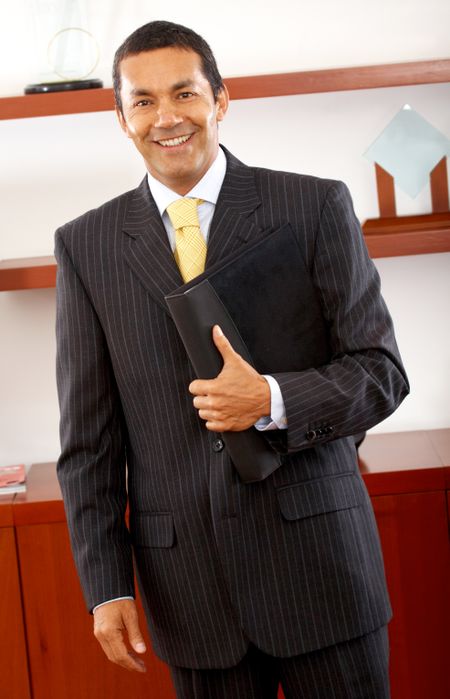 happy business man in his office holding a folder