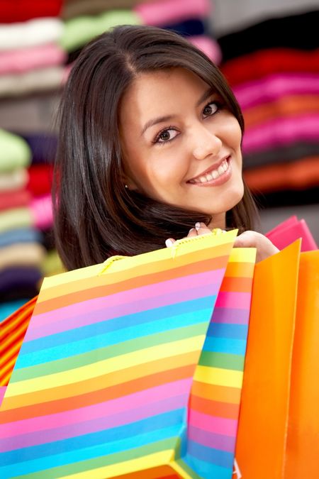 woman smiling with shopping bags in a shopping centre