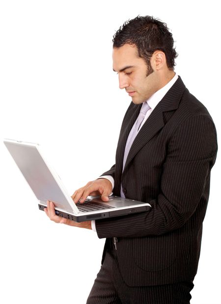 Business man standing and working on a laptop computer - isolated over a white background