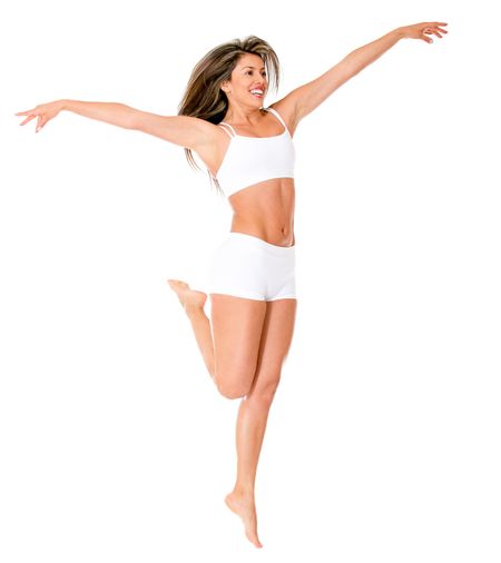 Fit woman in her underwear jumping - isolated over a white background