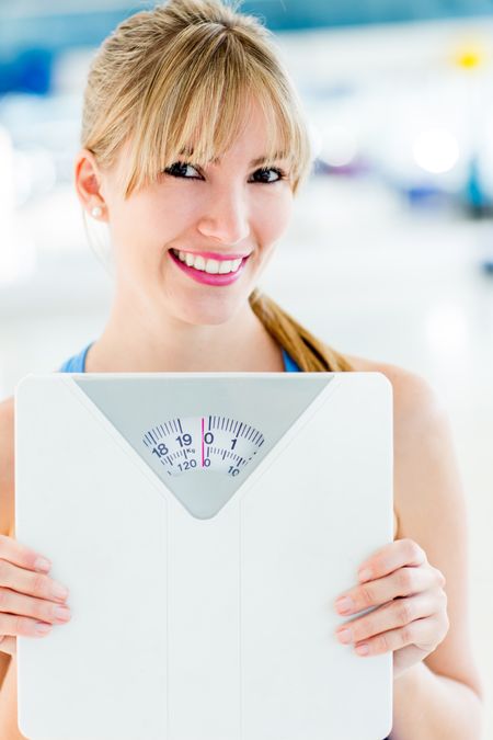 Beautiful woman loosing weight and holding a scale