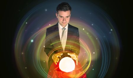 Young handsome man looking to the future of the universe in a crystal ball