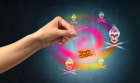 Female hand delivers illegal capsules with death s head wallpaper