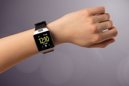 Naked female hand with smart wristwatch and digital clock on the screen