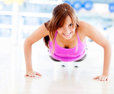 Woman exercising at the gym doing push ups