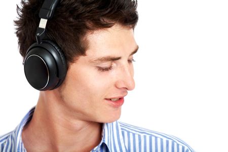 casual man listening to music in his headphones isolated over a white background