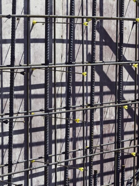 Construction abstract with high contrast: Grid of reinforcement rods ready for pouring of concrete to form exterior wall