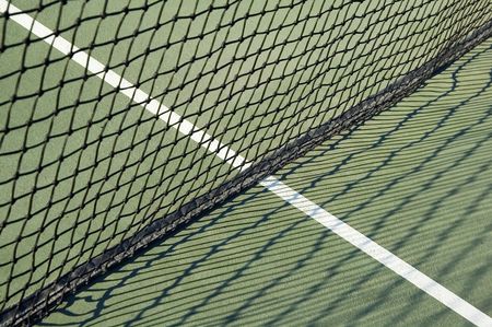 Net and shadows on outdoor tennis court