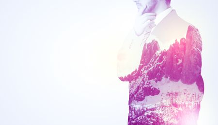  Young businessman in suit standing with sunny snowy mountain and trees graphic.