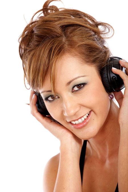 Friendly woman listening to music on her headphones isolated over a white background