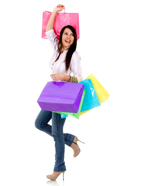 Excited shopping woman holding bags - isolated over a white background