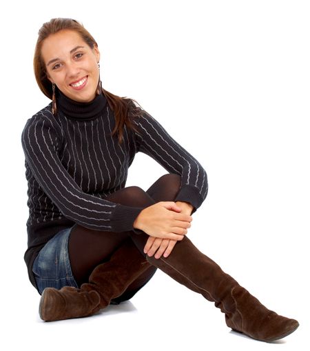 casual woman smiling sitting on the floor isolated over a white background