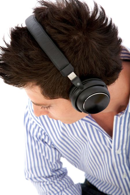 casual man listening to music in his headphones isolated over a white background