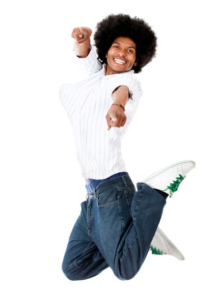 Happy man jumping and pointing at the camera - isolated over white
