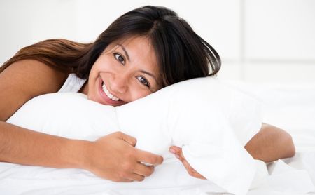 Happy woman lying in bed and relaxing