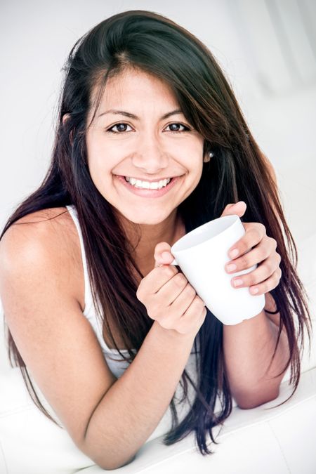 Happy woman drinking coffee - isolated over a white background